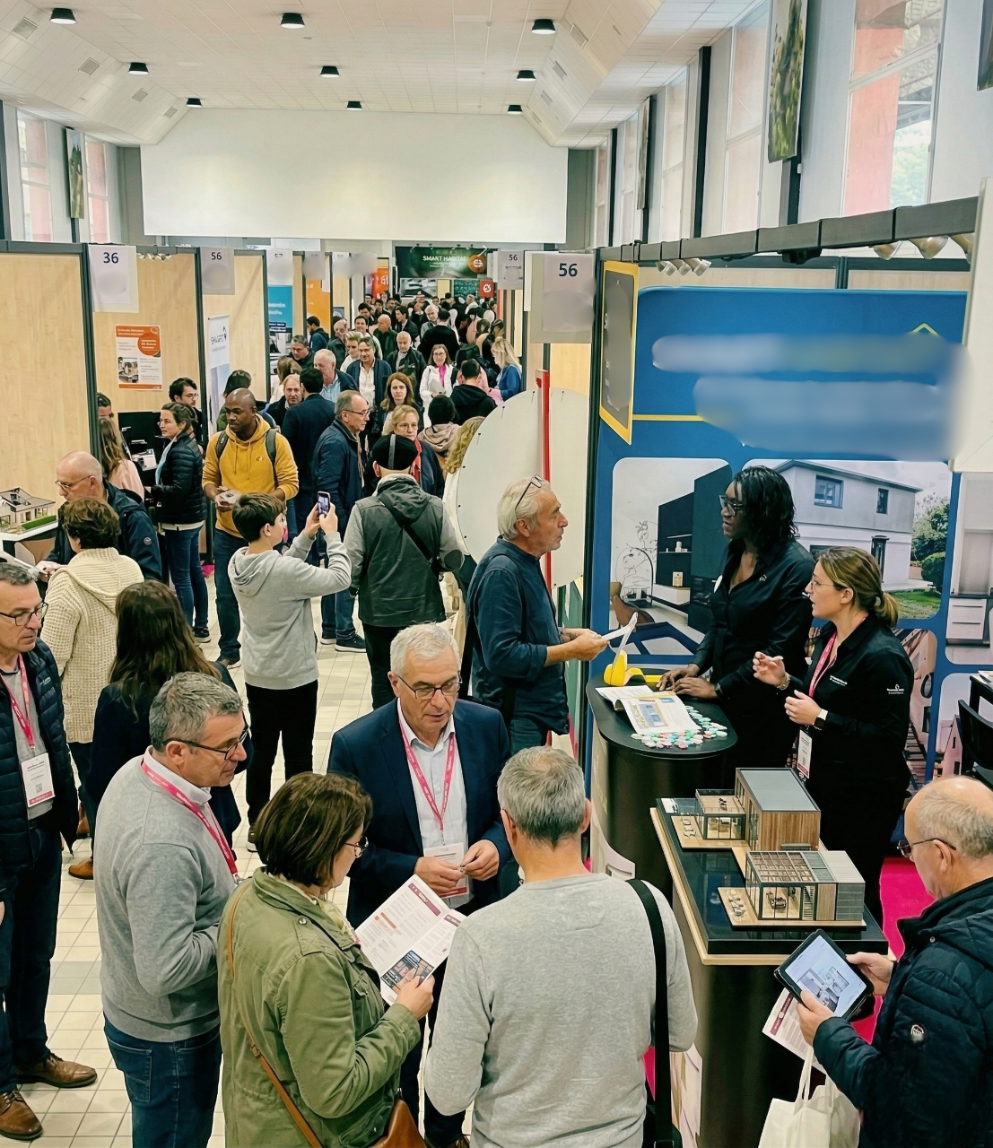 Visiteurs échangeant avec un exposant au salon de l'habitat
